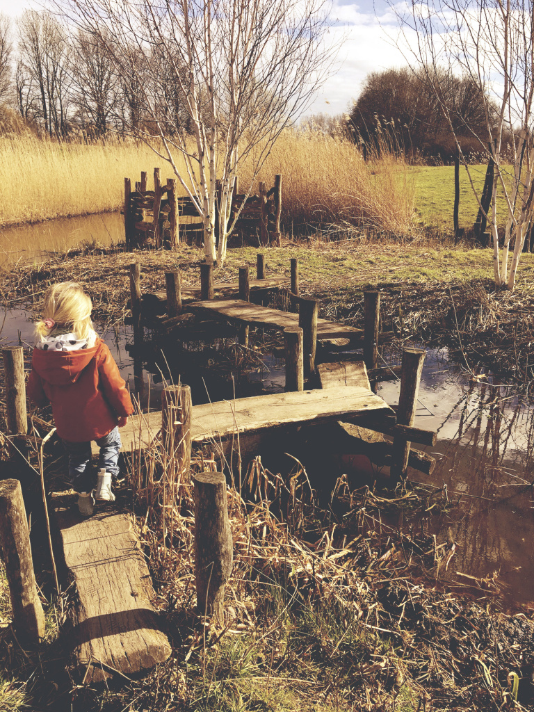 Lopen over houten bruggetjes in de natuurspeeltuin
